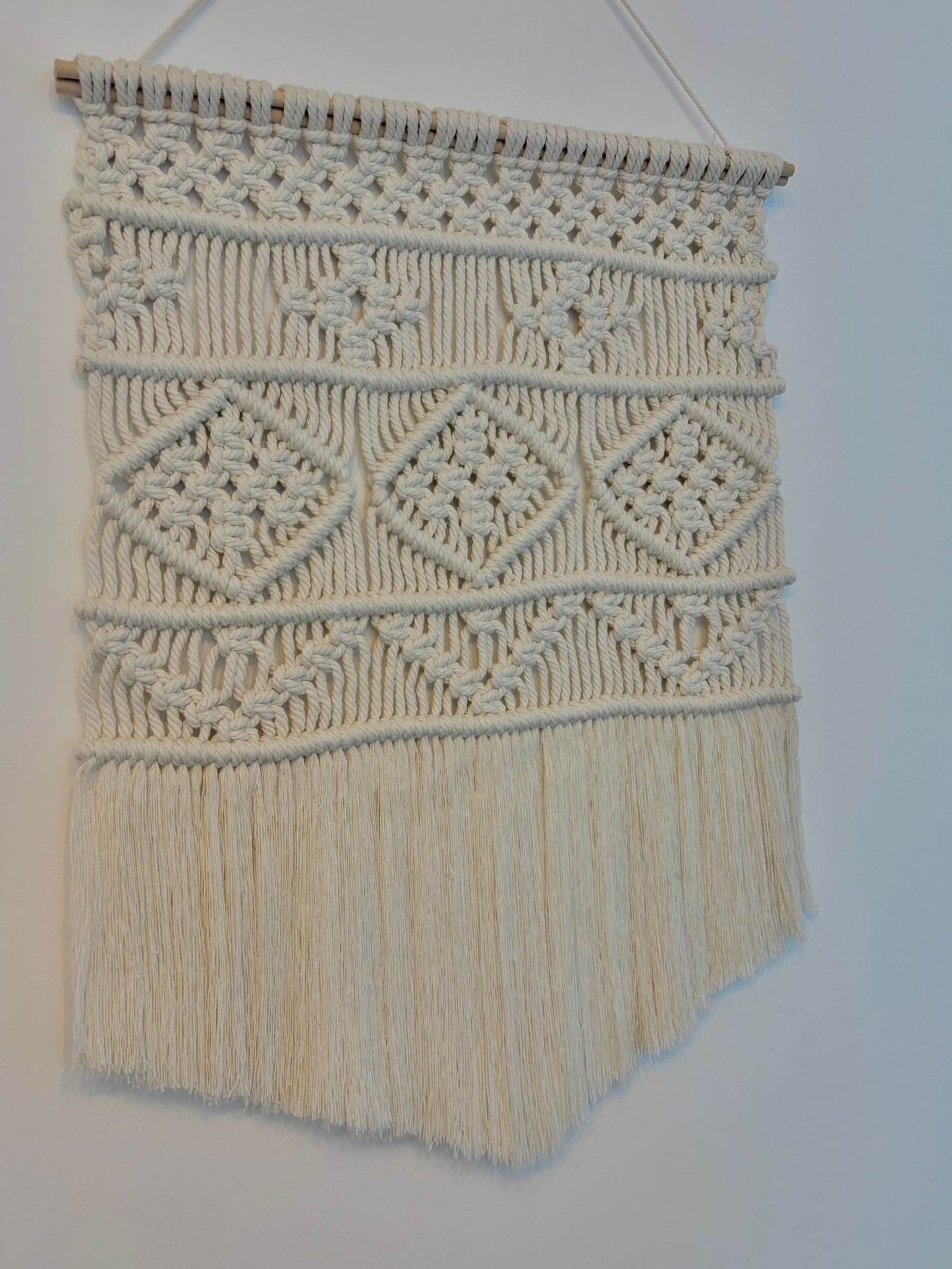 Small macrame wall hanging in v-shape