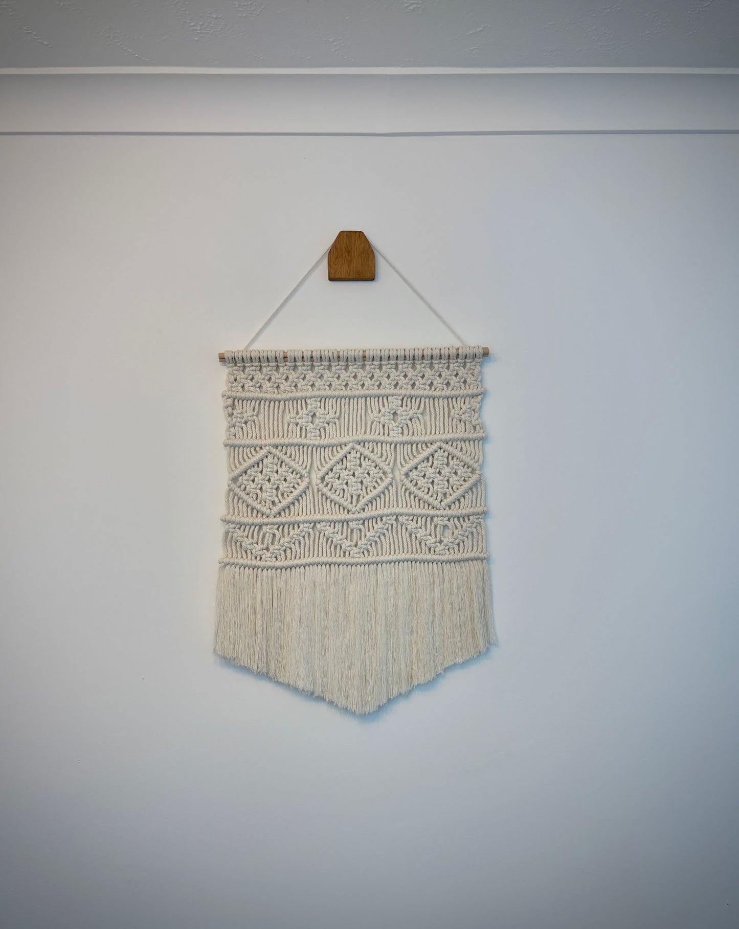 Small macrame wall hanging in v-shape