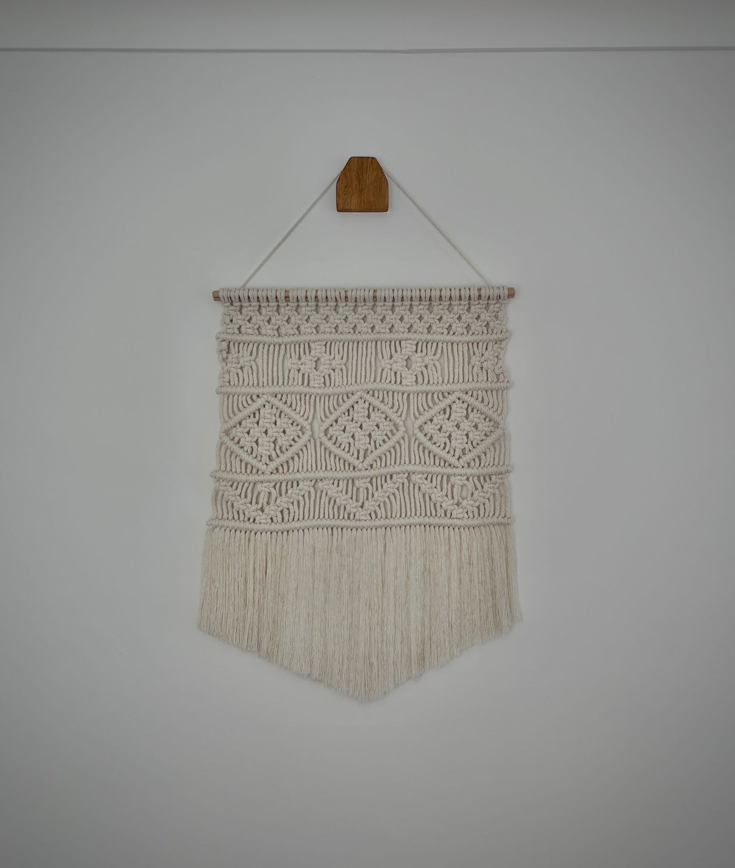 Small macrame wall hanging in v-shape