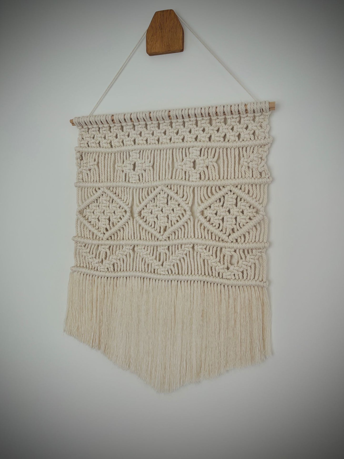 Small macrame wall hanging in v-shape